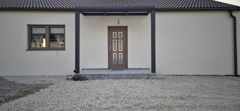 Bejárati ajtók fölé antracit színű polikarbonát előtető termék az Álomterasztól. Népszerű színek az antracit mellett a fehér termékek is. A tető polikarbonát műanyag és edzett üveggel is kérhető. Praktikus megoldás az eső ellen bejárati ajtó vagy a kerti kijárat fölé. Karbantartása egyszerű, gondozásmentes alumínium profilokból áll.