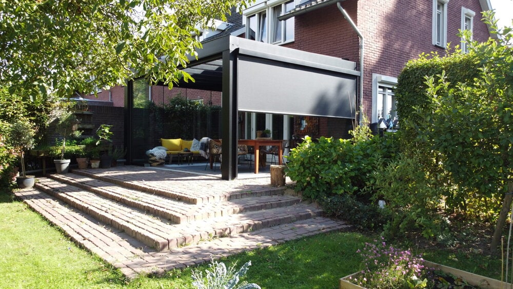 Terasz árnyékolóval felszerelt nyitott fedett terasz zöld kerttel